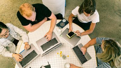 four people using laptop computers and smartphone