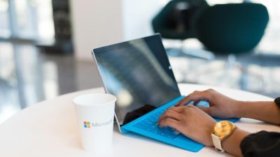 person browsing on black and blue laptop computer